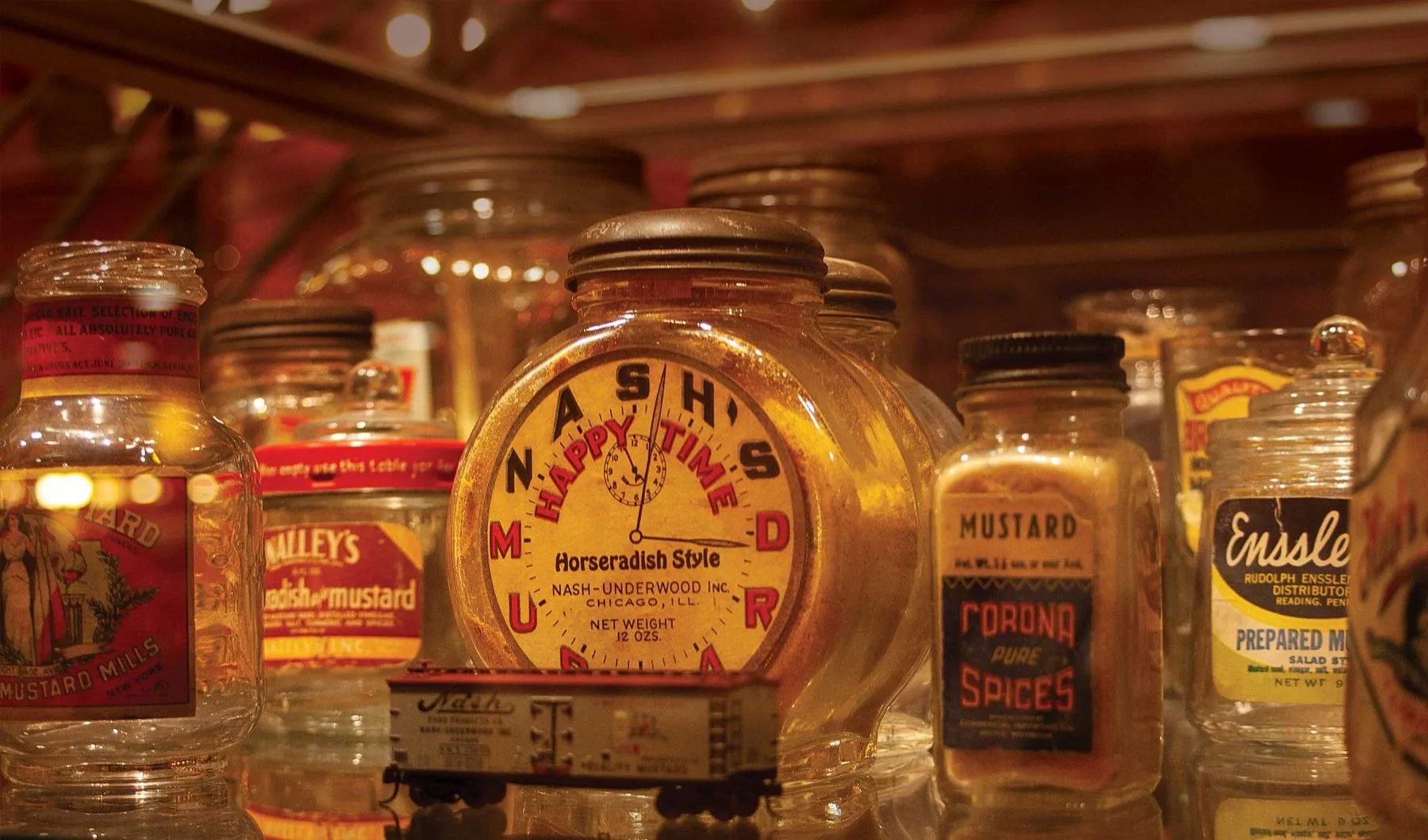 Vintage mustard jars under exhibit lighting