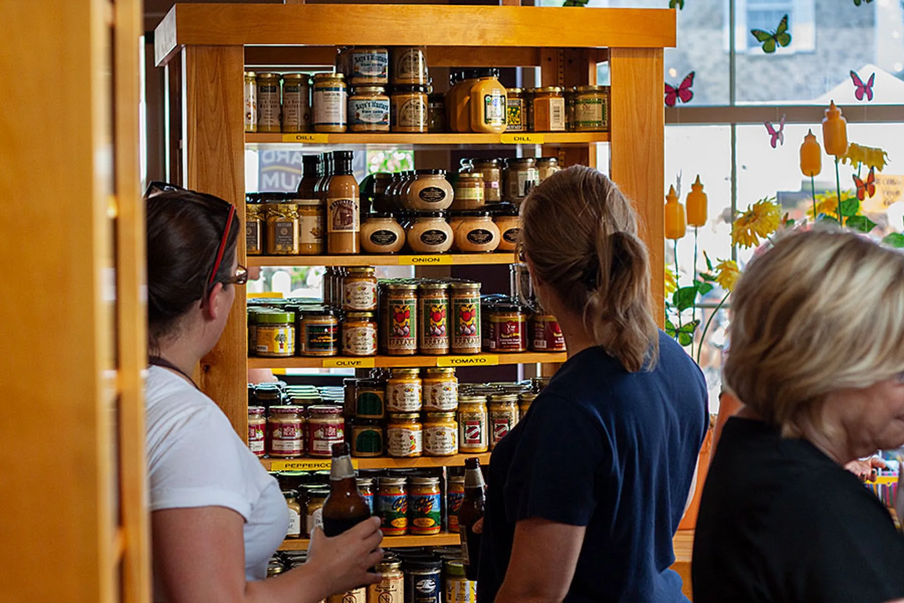 Wooden shelves full of jars beneath flavour signs in the gift shop